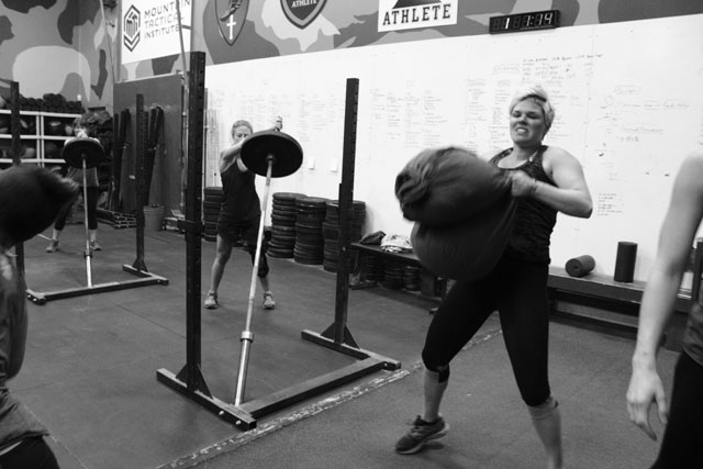 Erin completes the sandbag cleans in part (2). 